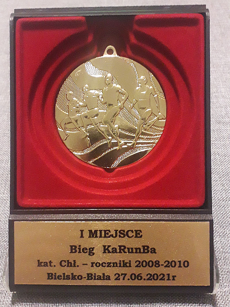Złoty medal w etui wraz z grawerem zawodów.